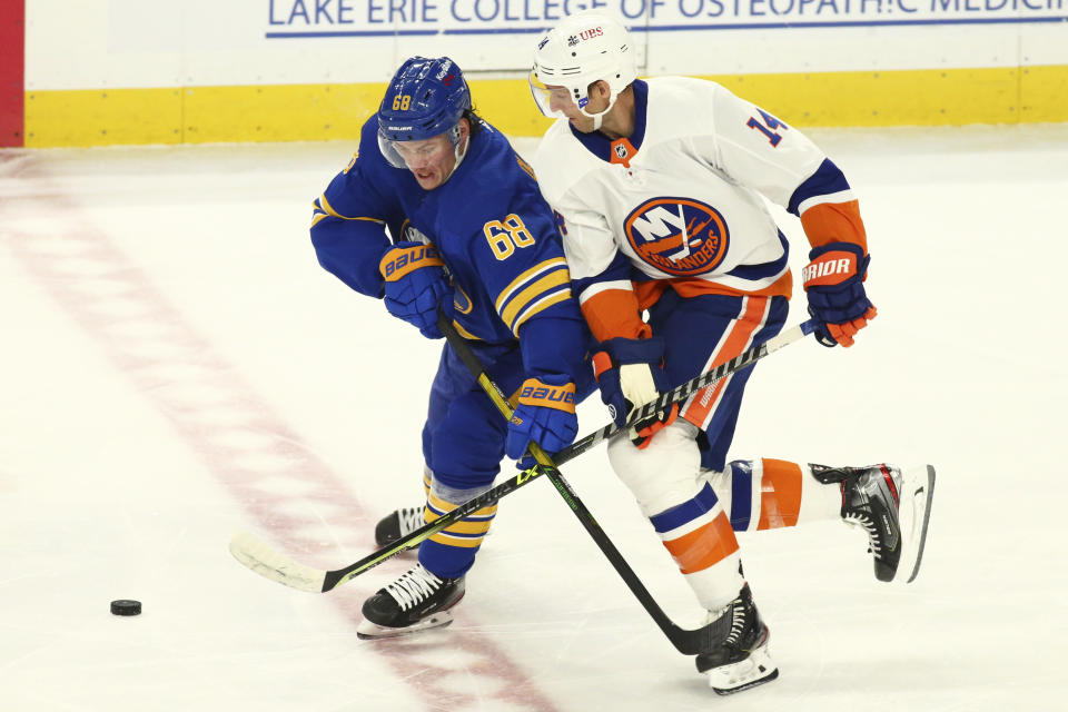 Buffalo Sabres forward Victor Olofsson (68) and New York Islanders forward Travis Zajac (14) battle for the puck during the first period of an NHL hockey game, Monday, May 3, 2021, in Buffalo, N.Y. (AP Photo/Jeffrey T. Barnes)