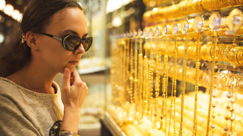 woman looking at gold jewelry