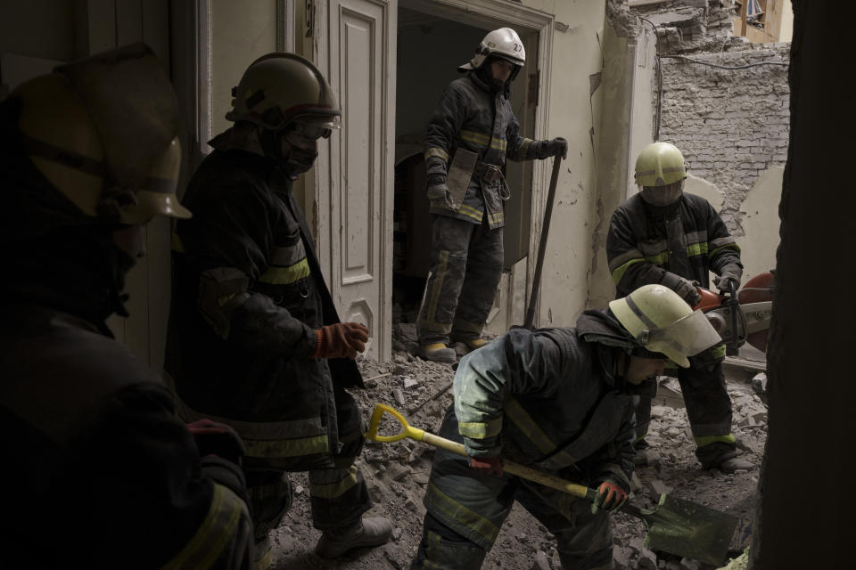 Emergency workers search for bodies under the debris of the regional administration building, heavily damaged after a Russian attack earlier this month in Kharkiv, Ukraine, Sunday, March 27, 2022. (AP Photo/Felipe Dana)