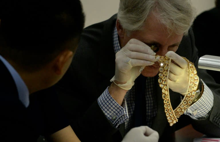 Christie's and Sotheby's auction house appraiser David Warren examines diamond jewellery seized by the Philippine government from former first lady Imelda Marcos, in Manila on November 24, 2015