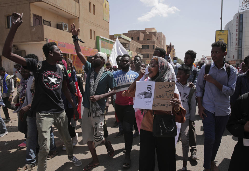 Sudanese protesters rally against the October 2021 military coup which has led to scores of deaths, thousands of injuries and numerous arrests of demonstrators, in Khartoum, Sudan, Monday, Feb. 28, 2022. Placard has a photo of a demonstrator who was killed and Arabic at left that reads, "A generation from light lives to enlighten." (AP Photo/Marwan Ali)