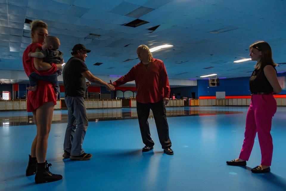 Astro Skate owner Chris Maganias, center, shakes hands with painter and muralist Michael Alexander after agreeing on a price for a new mural at the newest Astro Skate location in Greenacres, Fla., on March 1, 2023.