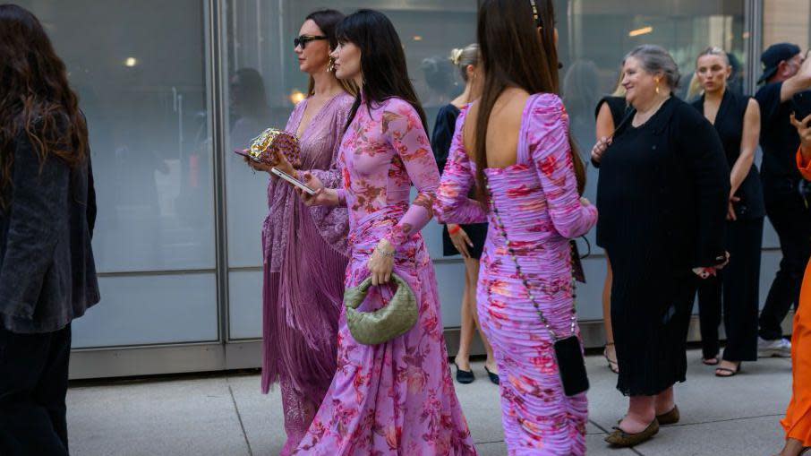 Women outside Pat Bo's New York show wearing pink and purple floral dresses 