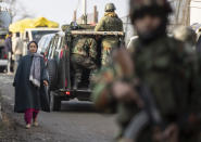 A Kashmiri woman walks past security officers keeping guard near the site of an attack on the outskirts of Srinagar, Indian controlled Kashmir, Thursday, Nov. 26, 2020. Anti-India rebels in Indian-controlled Kashmir Thursday killed two soldiers in an attack in the disputed region’s main city, the Indian army said.(AP Photo/Mukhtar Khan)