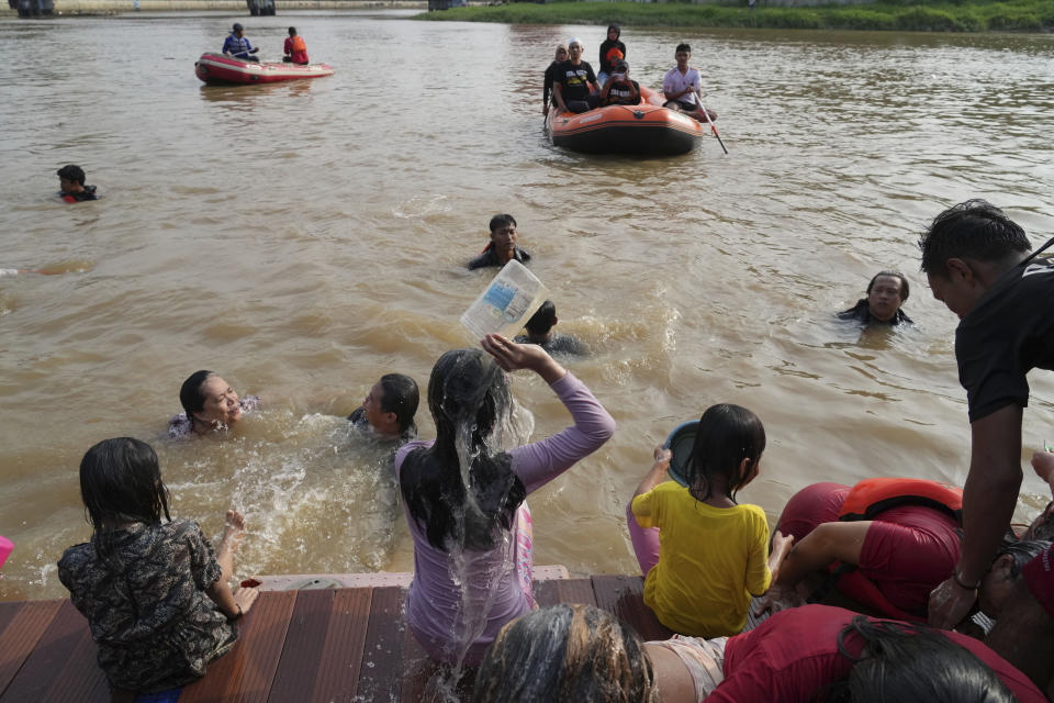 People bathe in the Cisadane River, ahead the holy fasting month of Ramadan in Tangerang, Indonesia, Tuesday, March 21, 2023. Muslims followed local tradition to wash in the river to symbolically cleanse their soul prior to entering the holiest month in Islamic calendar. (AP Photo/Tatan Syuflana)
