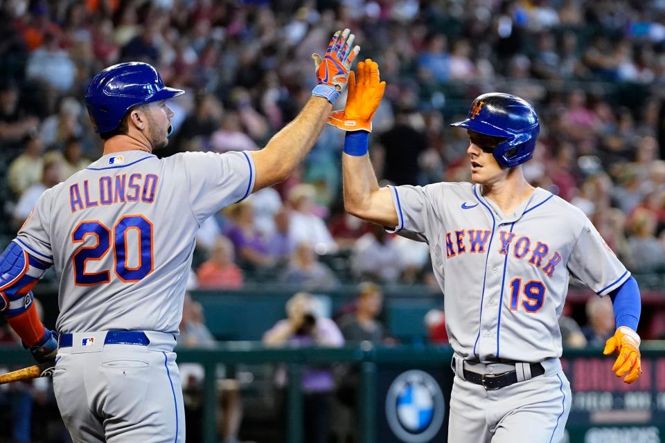 New York Mets' Mark Canha (19) celebrates his run scored against the Arizona Diamondbacks with teammate Pete Alonso (20) during the first inning of a baseball game Sunday, April 24, 2022, in Phoenix.