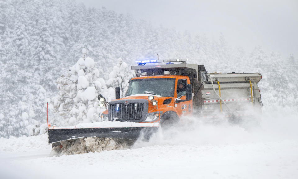 A Colorado Department of Transportation snow plow clears the eastbound lanes U.S. Highway 24 outside Woodland Park, Colo., Thursday, March 14, 2024. A major storm is dumping heavy, wet snow in Colorado — forcing flight cancellations and shutting down a highway that connects Denver to Colorado ski resorts. (Christian Murdock/The Gazette via AP)