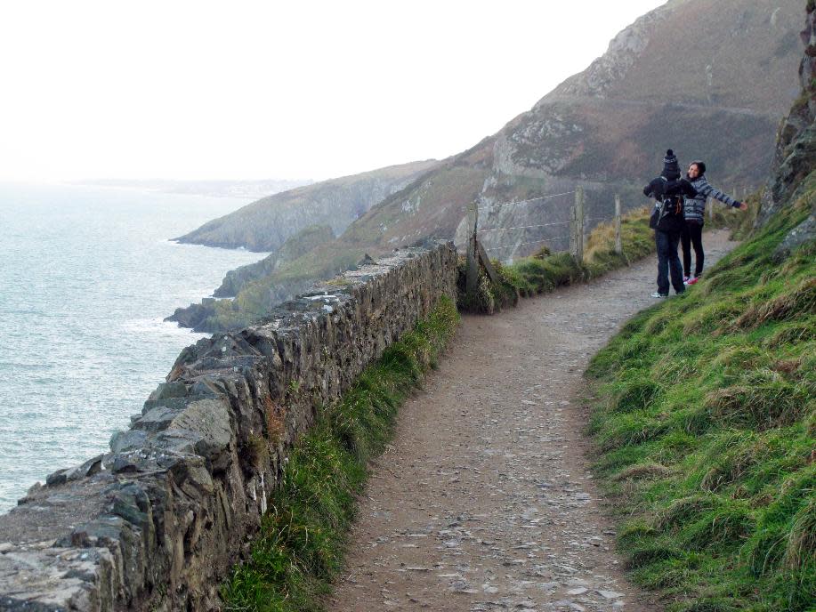 This Feb. 17, 2013 photo shows a coupl taking in the panoramic view on the Bray-to-Greystones cliff walk south of Dublin, Ireland. The 8-kilometer (5-mile) path closely parallels Dublin's commuter train line along the coast, and hikers can catch the train back to Dublin from either Bray or Greystones. (AP Photo/Shawn Pogatchnik)