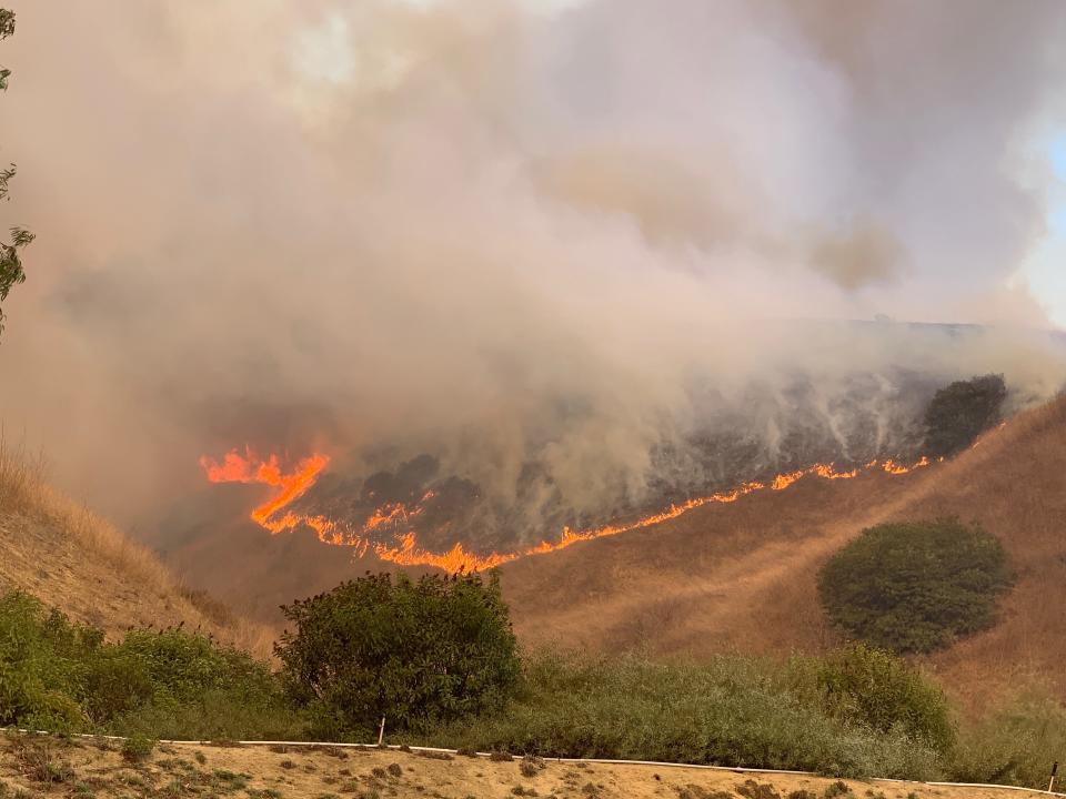 Flames from the Blue Ridge Fire can be seen on a ridge above Yorba Linda, Calif., on Oct. 26, 2020.