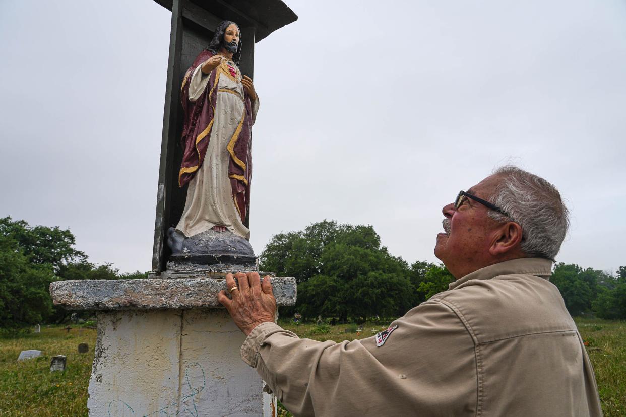 Juan Rodriguez looks up at a statue of Jesus Christ at the entrance of the San Jose Cemetery in East Austin on Saturday, April 20, 2024. Rodriguez siad he personally repairs to the statue whenever it gets damaged.