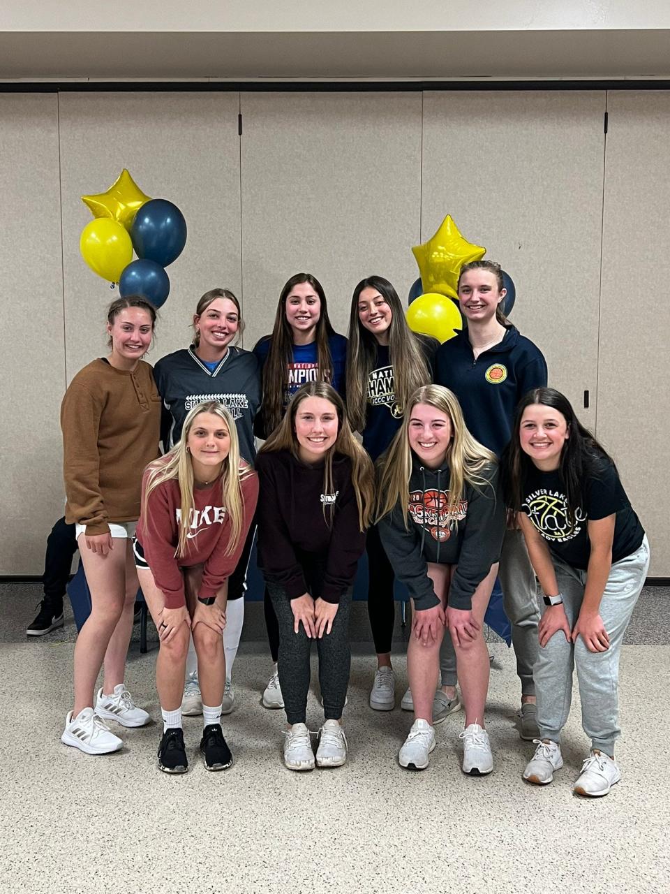 Camilla Ossola (top row, second from right) and the Silver Lake volleyball team gather April 20 after Ossola signed a letter of intent to continue her volleyball career at Johnson County Community College.