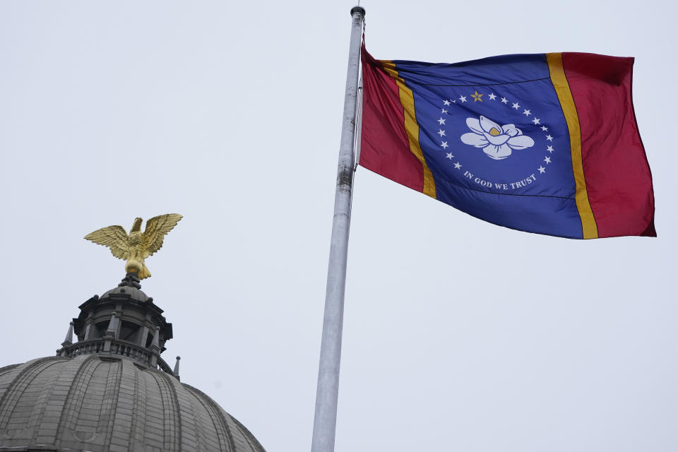 The new Mississippi state flag flies under the eagle at the top of the Capitol rotunda following the ceremonial unfurling in Jackson, Monday, Jan. 11, 2021. Earlier in the afternoon, Republican Gov. Tate Reeves signed a law that created the new state flag with magnolia at the center, six months after the state retired the last state flag in the U.S. that included the Confederate battle emblem. (AP Photo/Rogelio V. Solis)