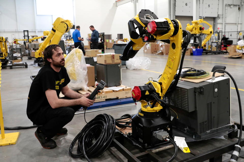 Robot technician Justin McPhail prepares a manufacturing robot for shipping to a customer in a FANUC American facility in Auburn Hills, Michigan, August 11, 2021. REUTERS/Rebecca Cook