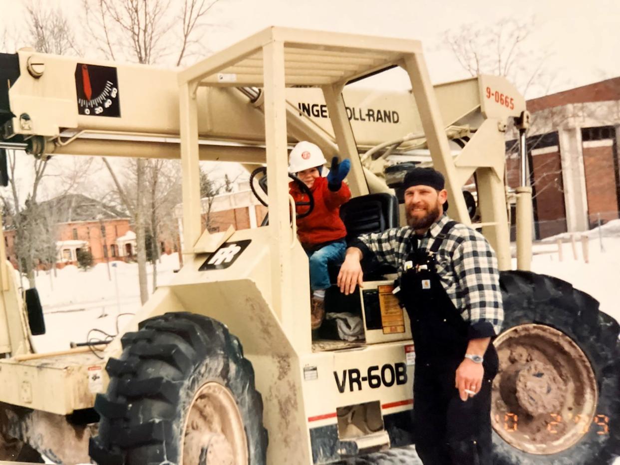 Rob and Tiffany Younk on a piece of heavy construction equipment in Sault Ste. Marie at the construction site of Lake Superior State University.