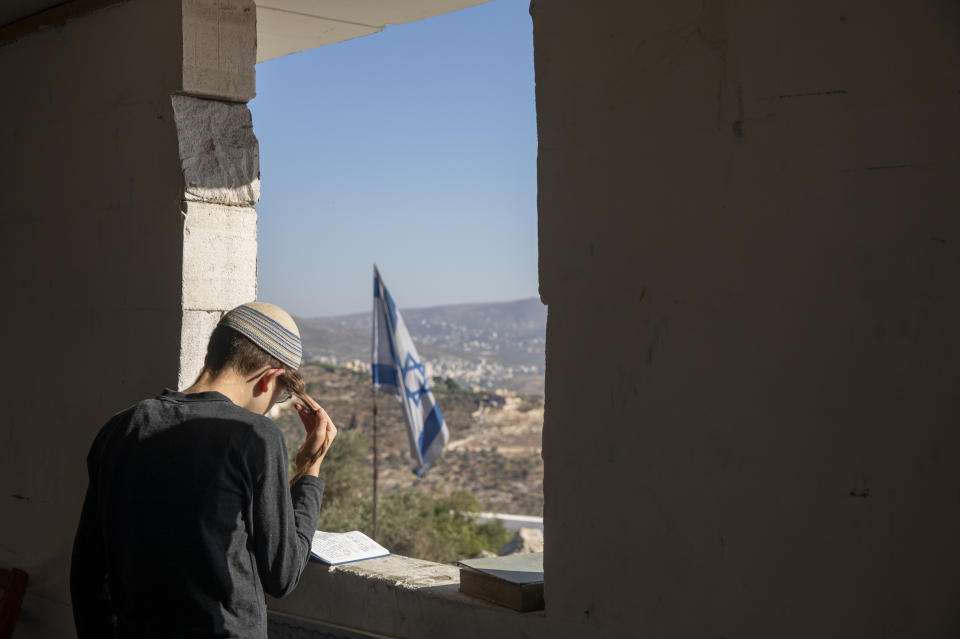 An Israeli settler prays in a synagogue at the outpost of Eviatar near the northern Palestinian West Bank town of Nablus, Sunday, June 27, 2021. Palestinians from the West Bank town of Beita have been holding regular protests against Eviatar, the nearby Jewish settlement outpost that was rapidly established last month. The Palestinians say it was established on their farmland. At least four protesters have been killed in clashes with Israeli troops. (AP Photo/Ariel Schalit)