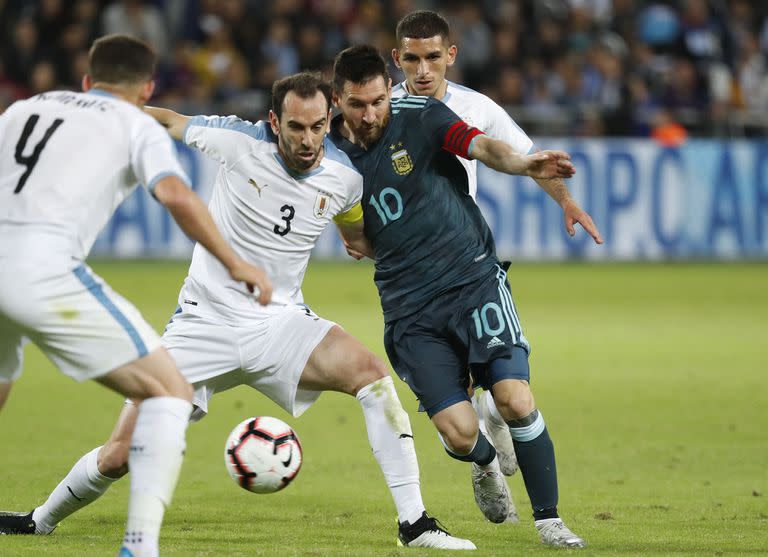 Duelo de fuerza: Diego Godín busca cerrarle el paso a Messi en un amistoso jugado en el Bloomfield Stadium de Tel Aviv en noviembre de 2019