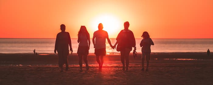 A family on a beach at sunset