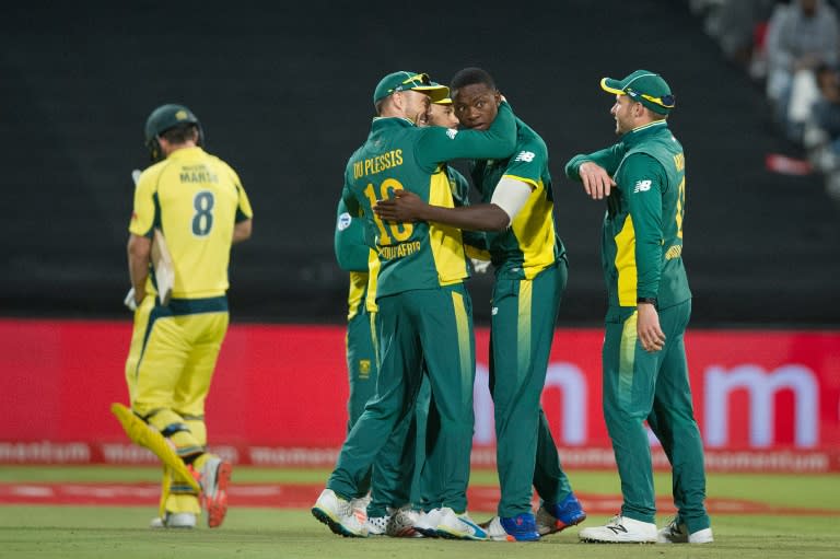 South African team members congratulate Kagiso Rabada (C) after hebowled Australia's Mitchell Marsh (L) out during the One Day International Cricket match on October 12, 2016, in Cape Town