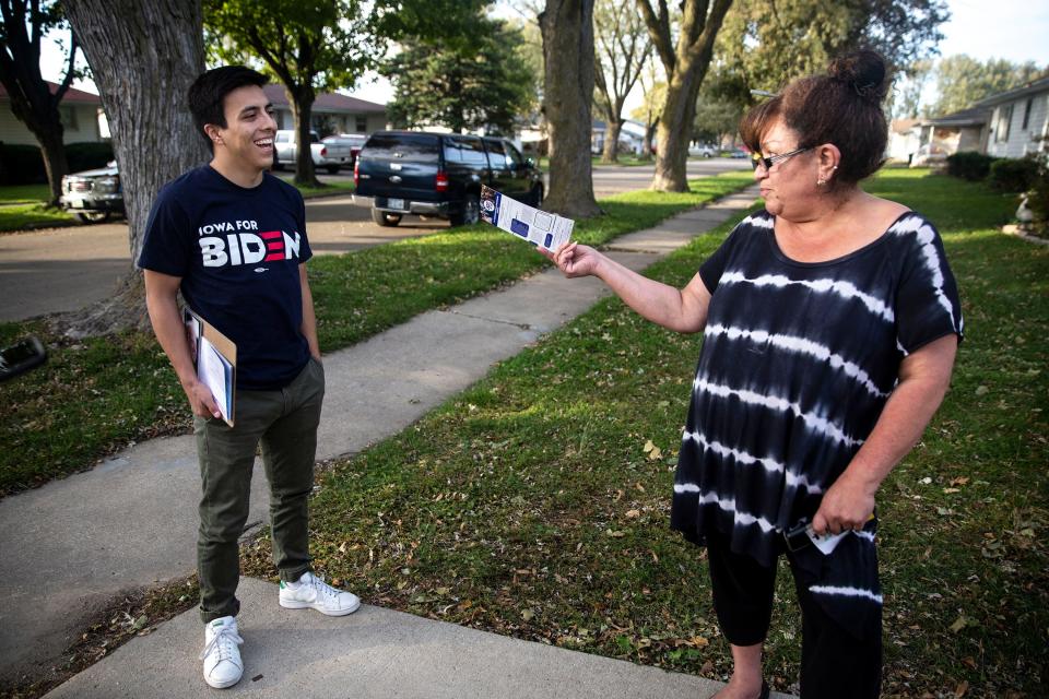 Camilo Haller, a field organizer for Joe Biden's campaign for president, talks to Sandra Armento, of Storm Lake, while knocking doors on Thursday afternoon, Oct. 17, 2019, in Storm Lake.  