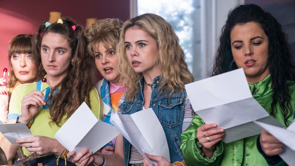 the cast of Derry Girls hold papers in Derry Girls season 3