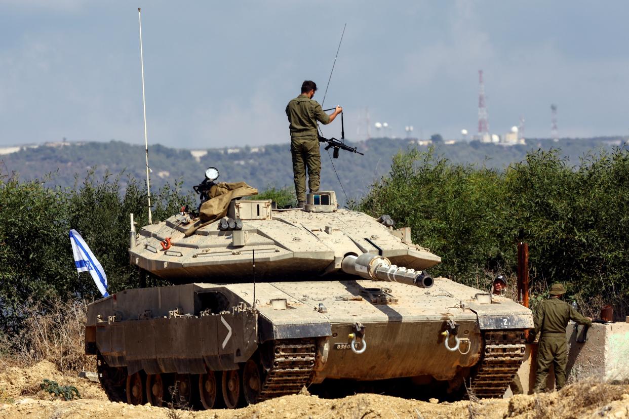 An Israeli soldier adjusts his rifle as he stands on a tank near Israel's border with Lebanon (REUTERS/Lisi Niesner)
