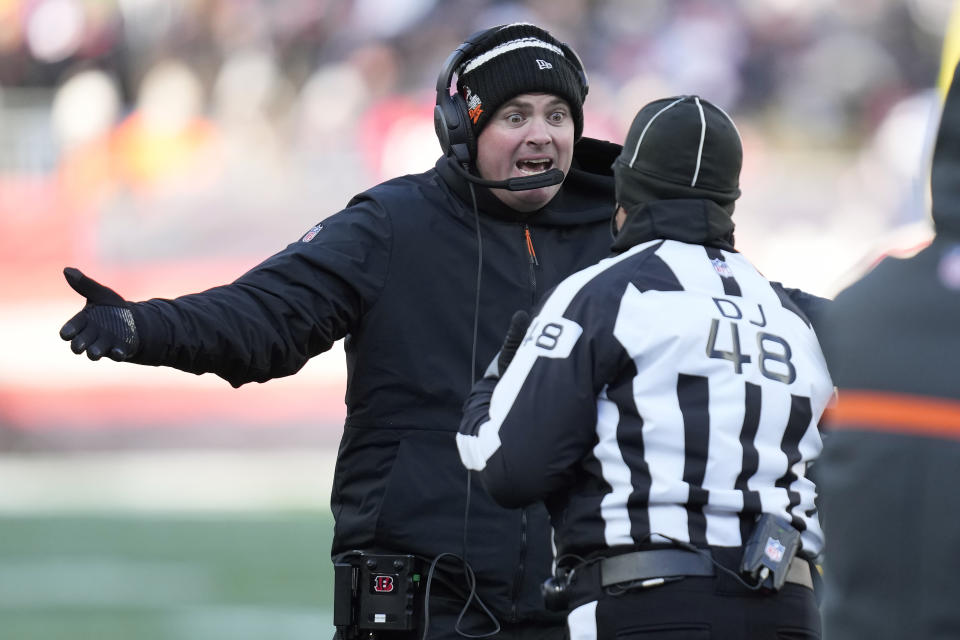 Cincinnati Bengals head coach Zac Taylor, left, speaks with down judge Jim Mello (48) during the first half of an NFL football game against the New England Patriots, Saturday, Dec. 24, 2022, in Foxborough, Mass. (AP Photo/Charles Krupa)