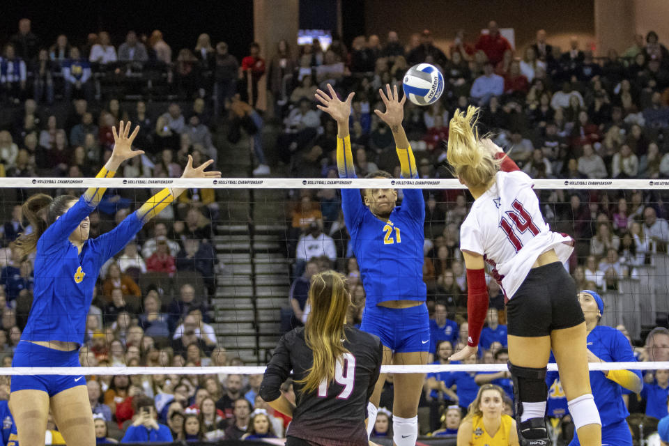 Pittsburgh Serena Gray (21) jumps to block Louisville Anna DeBeer (14) during the semifinals of the NCAA volleyball tournament, Thursday, Dec. 15, 2022 in Omaha, Neb. (AP Photo/John S. Peterson)