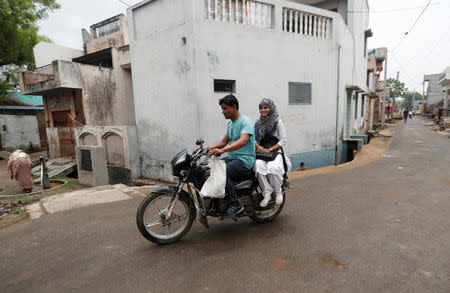 FILE PHOTO: Sharfuddin, a cloth shop owner and his niece Aisha, a law student, ride a motorbike in village Nayabans in the northern state of Uttar Pradesh, India May 15, 2019. REUTERS/Adnan Abidi
