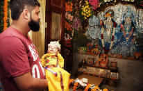 <p>An Indian man holding his newly born child dressed as Lord Krishna, prays at a temple on the occasion of Janmashtami in Jammu, India, Aug. 25, 2016. Janmashtami marks the birth of Lord Krishna. (Photo: Channi Anand/AP) </p>