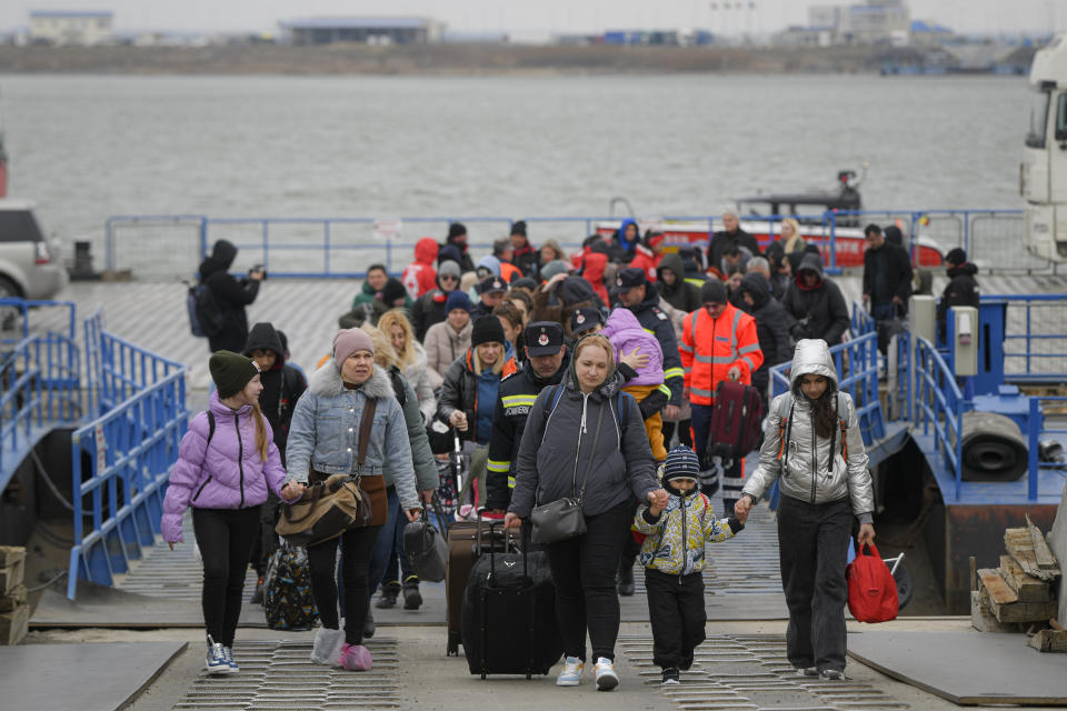 FILE - Refugees fleeing the war from neighboring Ukraine walk after crossing the border by ferry at the Isaccea-Orlivka border crossing in Romania, Friday, March 25, 2022.Since Russia launched its attacks against Ukraine on Feb. 24, more than 6 million people have fled war-torn Ukraine, the United Nations refugee agency announced Thursday, May 12, 2022. (AP Photo/Andreea Alexandru, File)