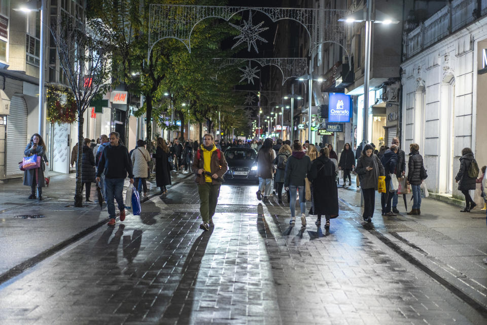 A car slowly makes its way through the pedestrians in the historic center of the city.