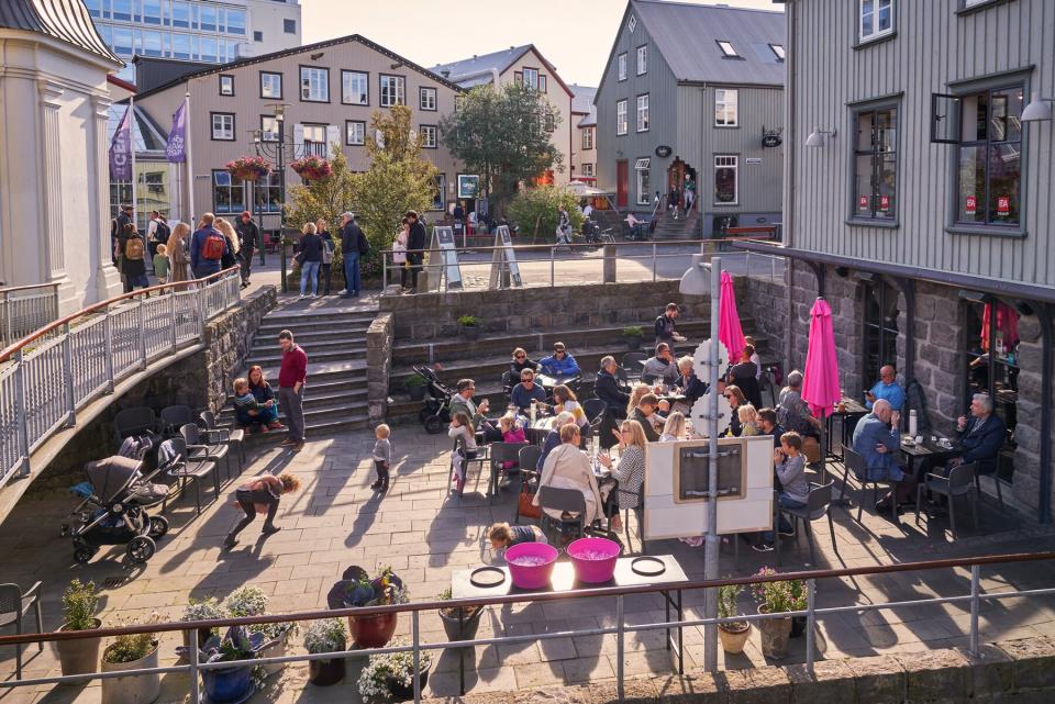 People outdoors at a cafe during, Menningarnott, Reykjavik, Iceland. Menningarnott is known as Cultural night in Reykjavik, a popular summer festival, Iceland.