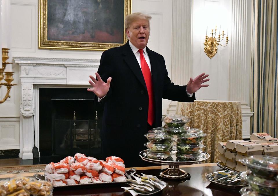 Then-President Donald Trump with a bunch of fast food in January 2019. Trump wanted to make poultry lines run faster even though workers were getting sick with COVID-19. (Photo: USA Today Sports / Reuters)