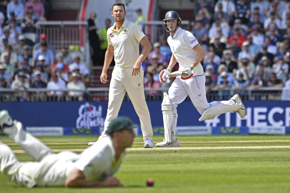 England's Zak Crawley, right, runs past Australia's Josh Hazlewood, left, after playing a shot during the second day of the fourth Ashes cricket Test match between England and Australia at Old Trafford in Manchester, England, Thursday, July 20, 2023. (AP Photo/Rui Vieira)