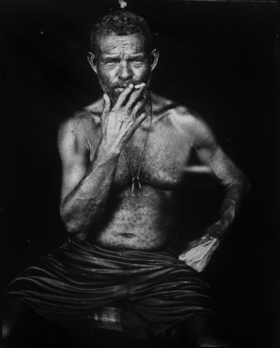 Fisherman Alejandro Elizalzabal smokes a cigarette as he sits for a portrait after a day's work on oil-contaminated Lake Maracaibo in Cabimas, Venezuela, July 3, 2019. (AP Photo/Rodrigo Abd)