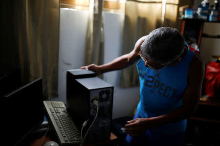 Guillermo Habanero, 56, a kidney transplanted patient, works on the computer of a client at his house in Caracas, Venezuela February 7, 2018. REUTERS/Carlos Garcia Rawlins