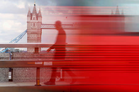 A man walks across London Bridge behind a barrier to prevent traffic mounting the pavement in London. REUTERS/Luke MacGregor