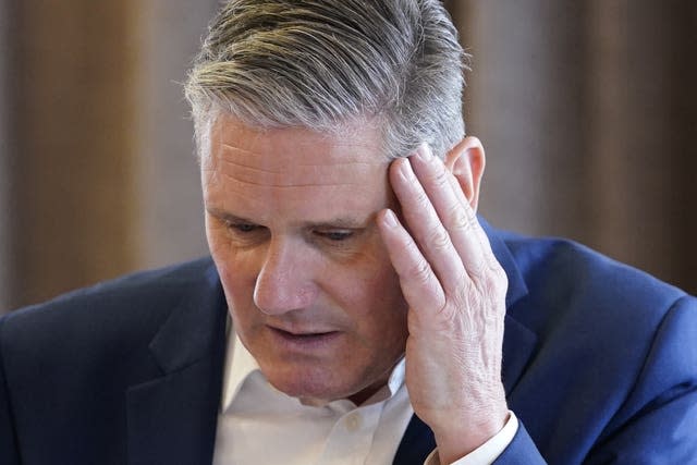Labour leader Sir Keir Starmer places his left hand on his left temple