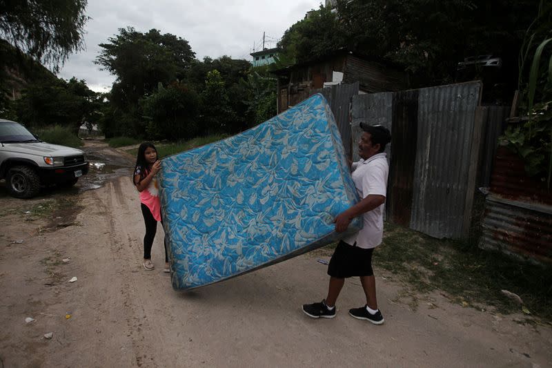 Residents carry a mattress as they evacuate their house in anticipation of heavy rains as Hurricane Iota approaches, in Tegucigalpa