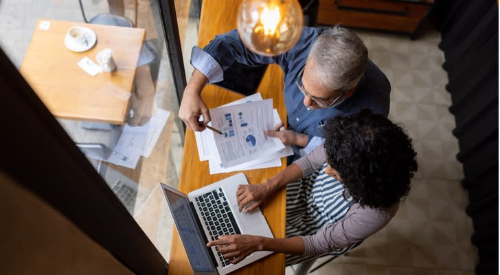 A married couple looks over their investment strategy together. 