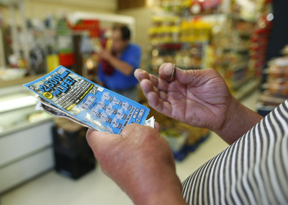 CHELSEA, MA - JUNE 4: A man scratches a lottery ticket at Tan-Thang Market on Broadway in Chelsea, Mass., June 4, 2014. (Photo by Jessica Rinaldi/The Boston Globe via Getty Images)