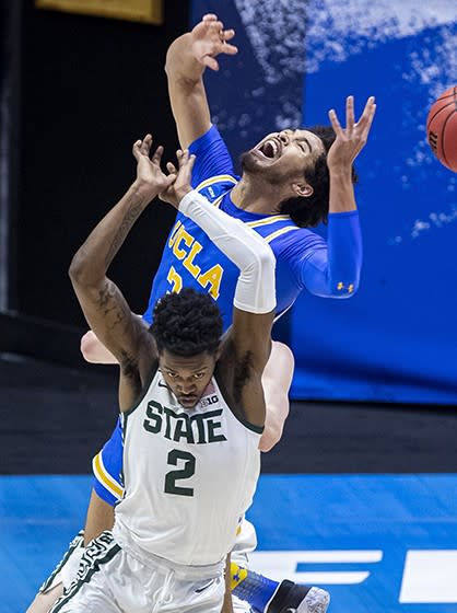 Michigan State's Rocket Watts, foreground, and UCLA's Johnny Juzang battle for a rebound in the first half Thursday.