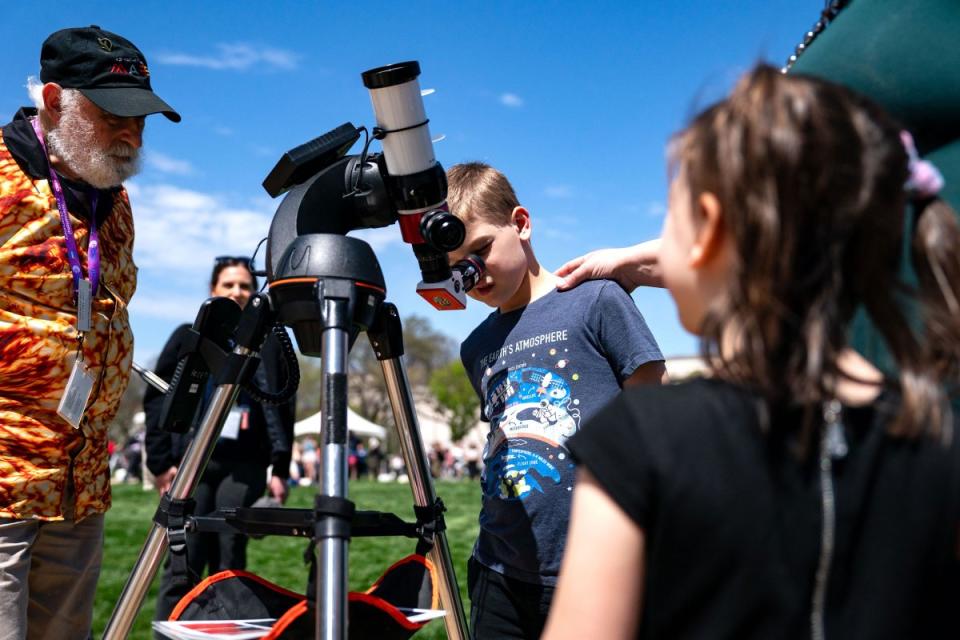 People look through a telescope that is tracking the path of the sun as people gather on the National Mall in Washington, D.C., to view the partial solar eclipse.<span class="copyright">Kent Nishimura—Getty Images</span>