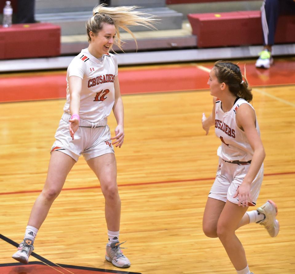 Bishop Kenny guard Sophia Rueppell (12) prepares to slap hands with teammate Reese Mayer (4) after Rueppell sank a 3-point shot against Ribault.