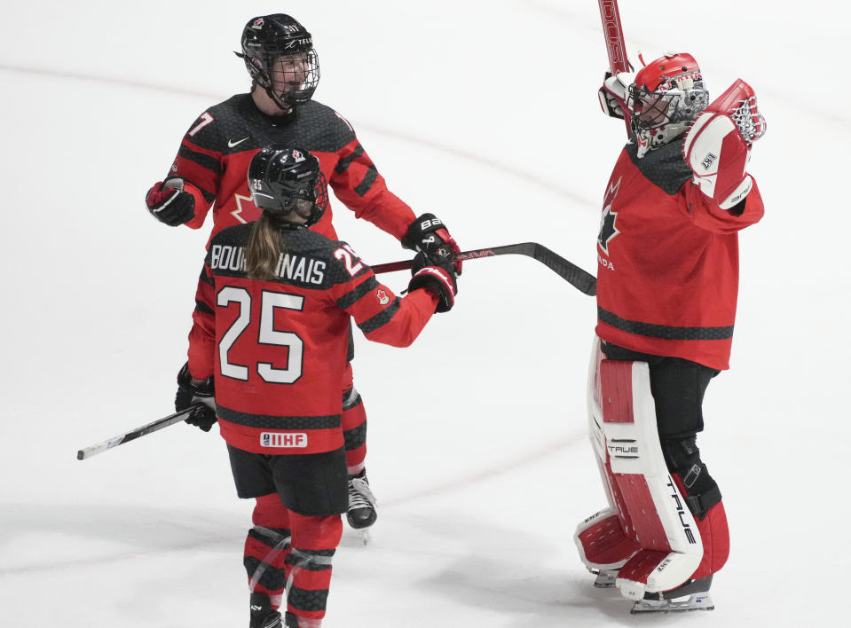 Canada goaltender Ann-Renee Desbiens (35) celebrates after her shutout win over Czechia with teammates Ella Shelton (17) and Jaime Bourbonnais (25) following a hockey match at the IIHF Women's World Championships in Utica, N.Y., Sunday, April 7, 2024. (Christinne Muschi/The Canadian Press via AP)