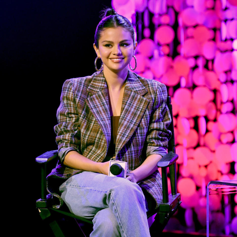 Selena Gomez sits and smiles in an interview
