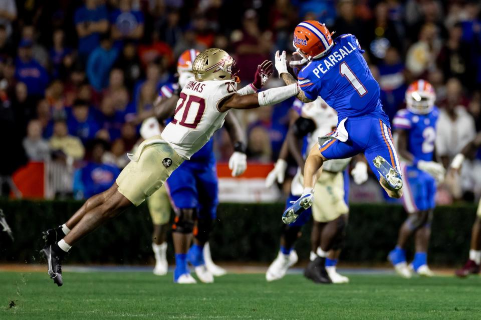 Florida Gators wide receiver Ricky Pearsall (1) makes a catch over Florida State Seminoles defensive back Azareye'h Thomas (20) during the second half at Steve Spurrier Field at Ben Hill Griffin Stadium in Gainesville, FL on Saturday, November 25, 2023. [Matt Pendleton/Gainesville Sun]