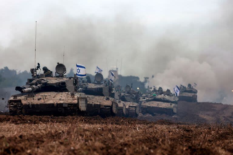 Una unidad de soldados israelíes regresa con sus tanques al lado israelí de la frontera con la Franja de Gaza, después de pasar meses en el territorio palestino participando en batallas con militantes de Hamás, el 28 de enero de 2024, mientras continúan los combates entre los dos bandos beligerantes (Menahem KAHANA / AFP)