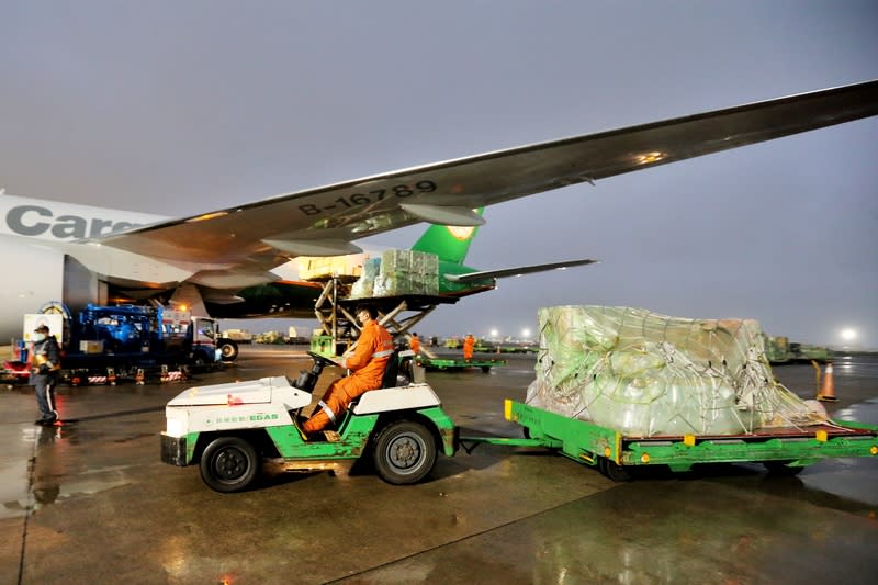 台灣自購默沙東 COVID-19口服藥，由長榮航空貨機運送，班機從美國芝加哥起飛後，在24日清晨5時18分運抵桃園國際機場，班機降落後滑行停靠在503機坪，先進行消毒靜置作業，隨即由地勤人員將放置於飛機貨艙的貨品卸下。中央社（讀者提供）