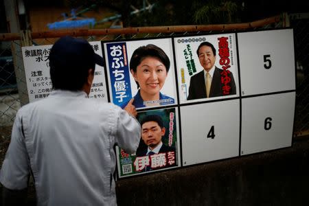 A local resident looks at candidates' posters for the October 22 lower house election in Nanmoku Village, northwest of Tokyo, Japan October 12, 2017. Picture taken October 12, 2017. REUTERS/Issei Kato